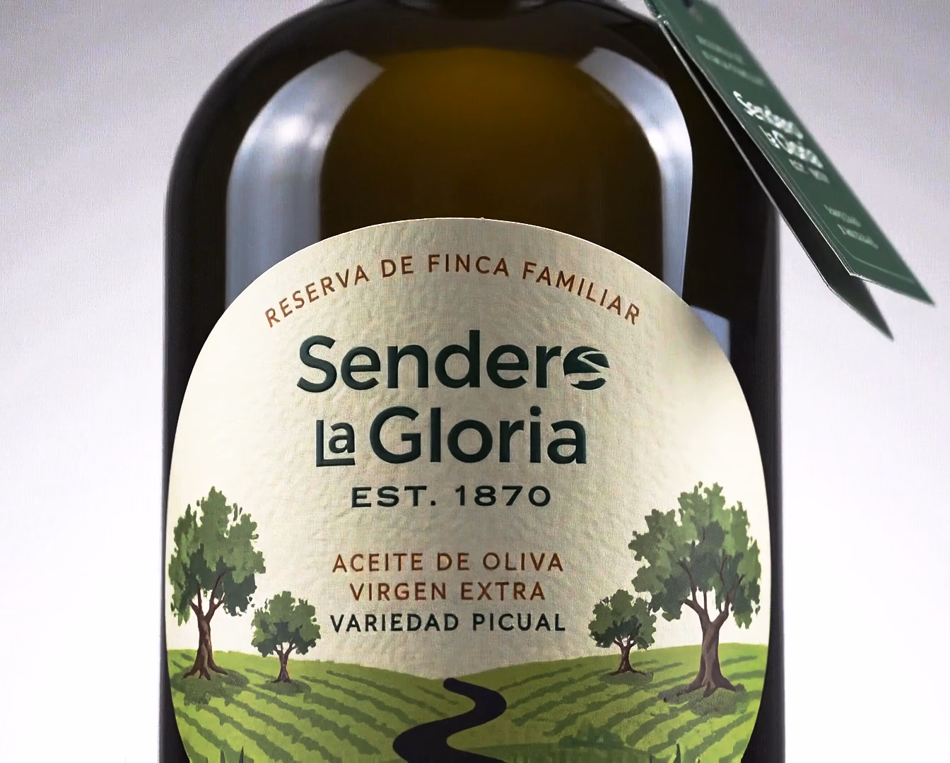 La botella de Sendero la Gloria gira despacio hasta poner la etiqueta de frente y después la cámara sube hasta el tapón y su sello con la «S»: reserva de finca familiar, est. 1870, aceite de oliva virgen extra, variedad picual, cosecha temprana.